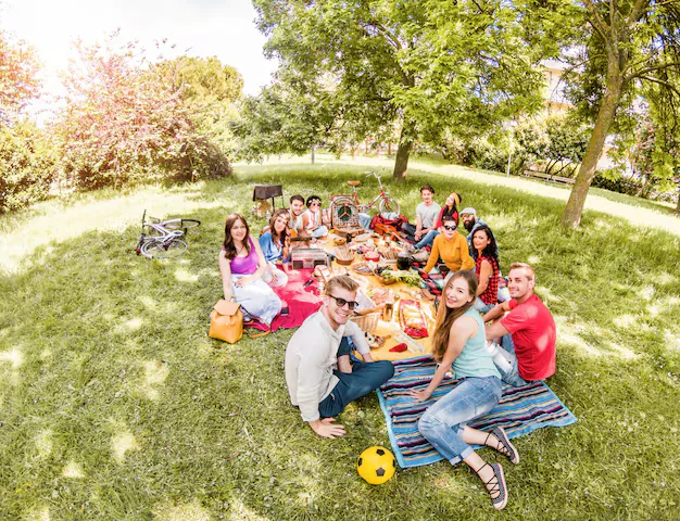 Groupe d'amis réuni autour d'un repas partagé lors d'un week-end en gîte de groupe
